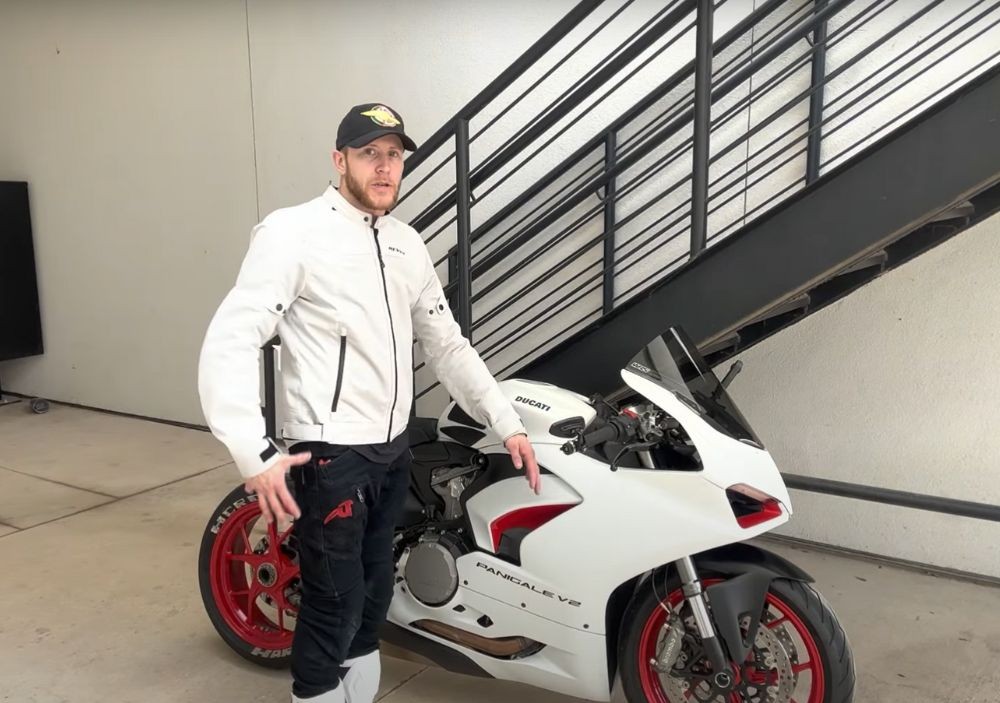 Rider in full summer outfit standing beside a Ducati Panigale V2, showcasing the Eclipse 2 jacket in white