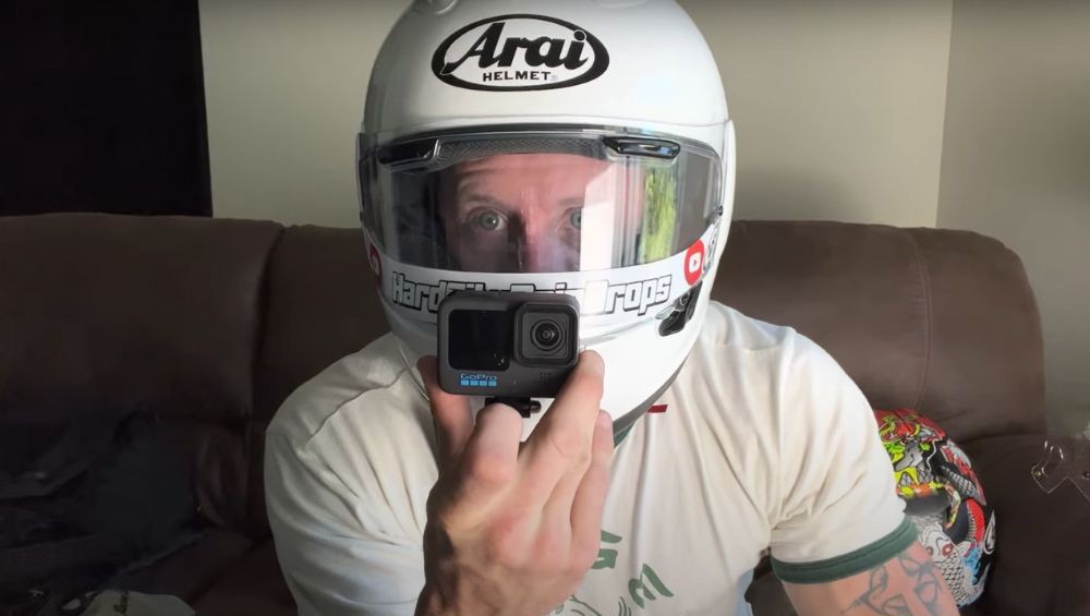 Rider wearing an Arai Corsair X helmet with a GoPro mounted low on the chin bar, just below the visor