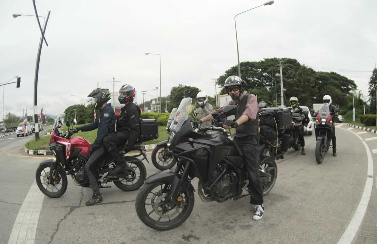 Group of motorcyclists at an intersection, wearing Bluetooth headsets and riding gear