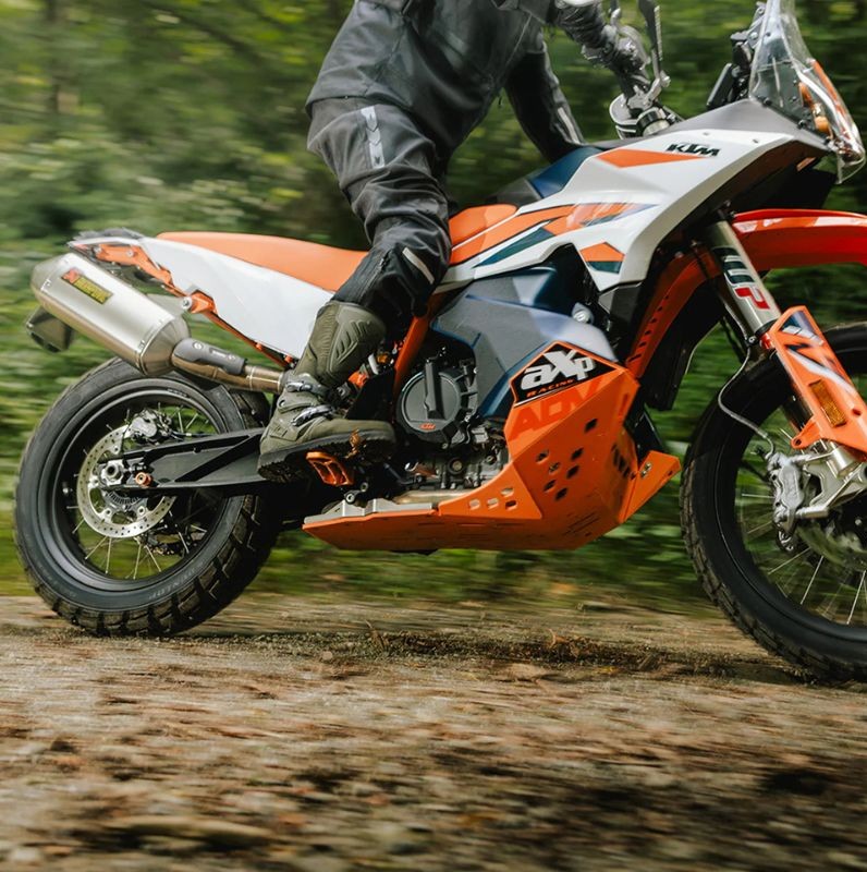 Rider wearing mid-to-high dual-sport boots on an off-road KTM motorcycle, showcasing boot height in action.