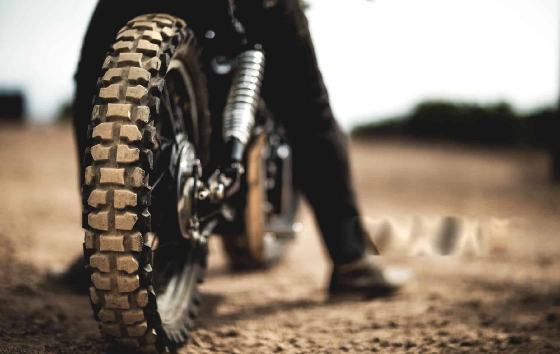 Close-up of a dirt bike tire on a trail, emphasizing tread detail