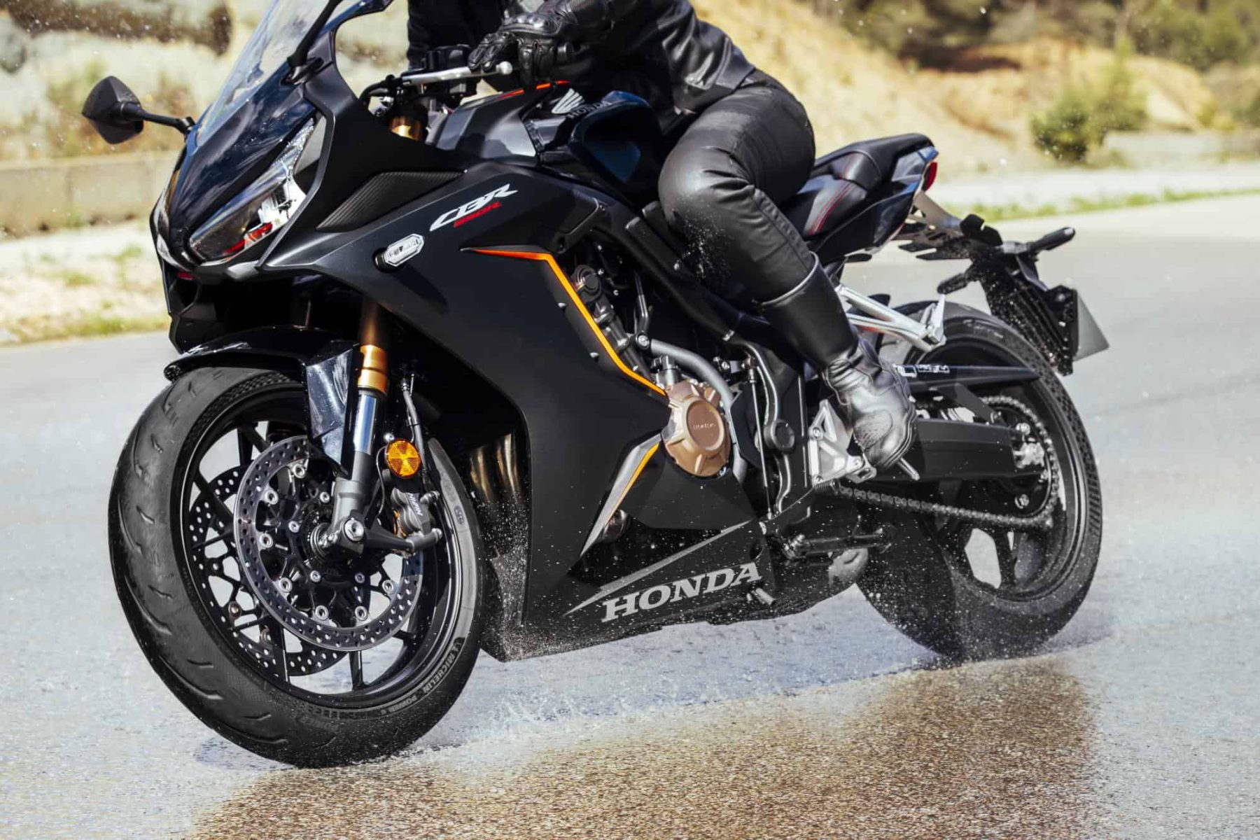 Sportbike rider leaning into a turn on wet pavement with Michelin Power 6 tires