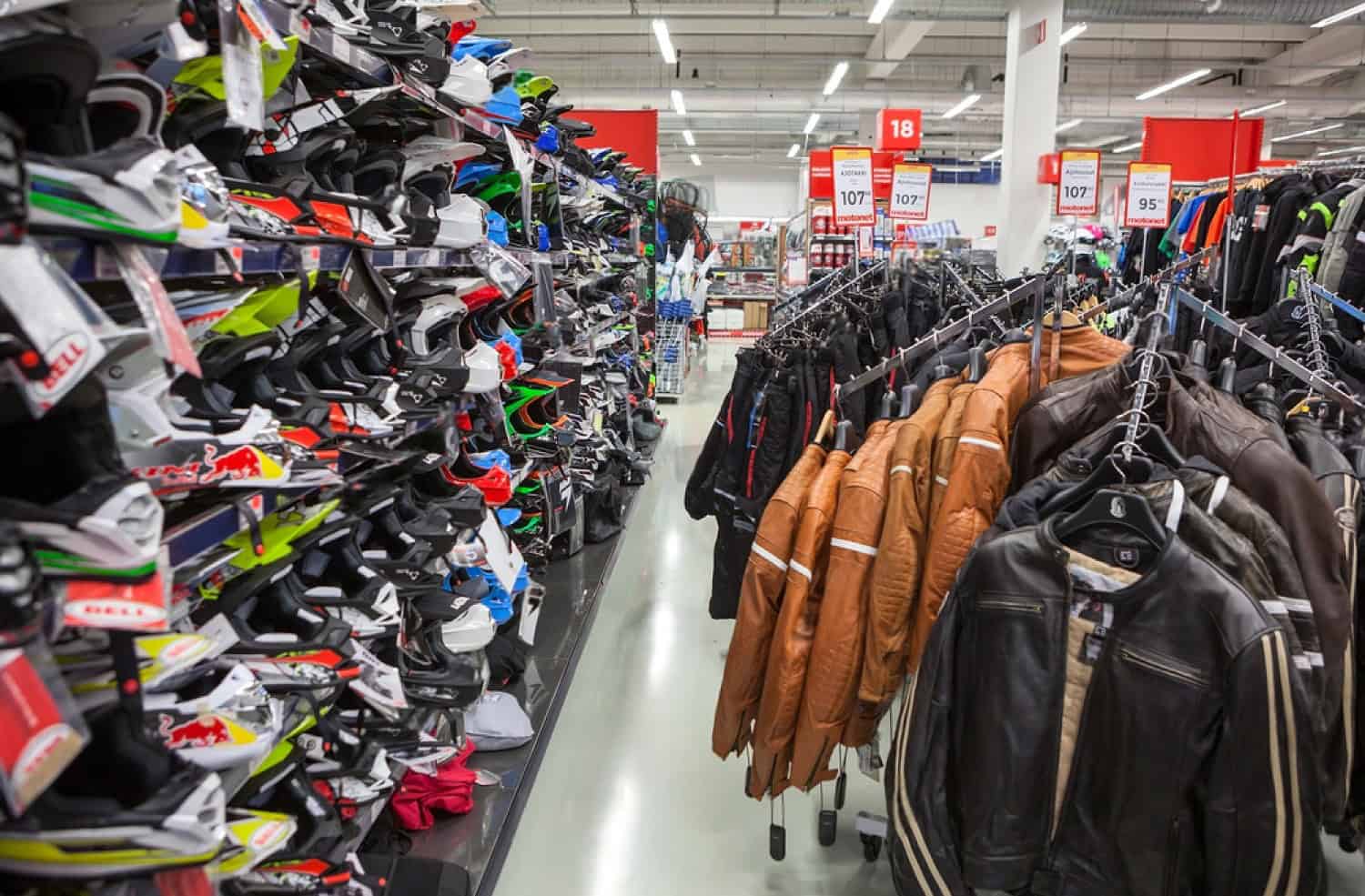 Motorcycle gear store aisle with helmets, jackets, and riding apparel on display
