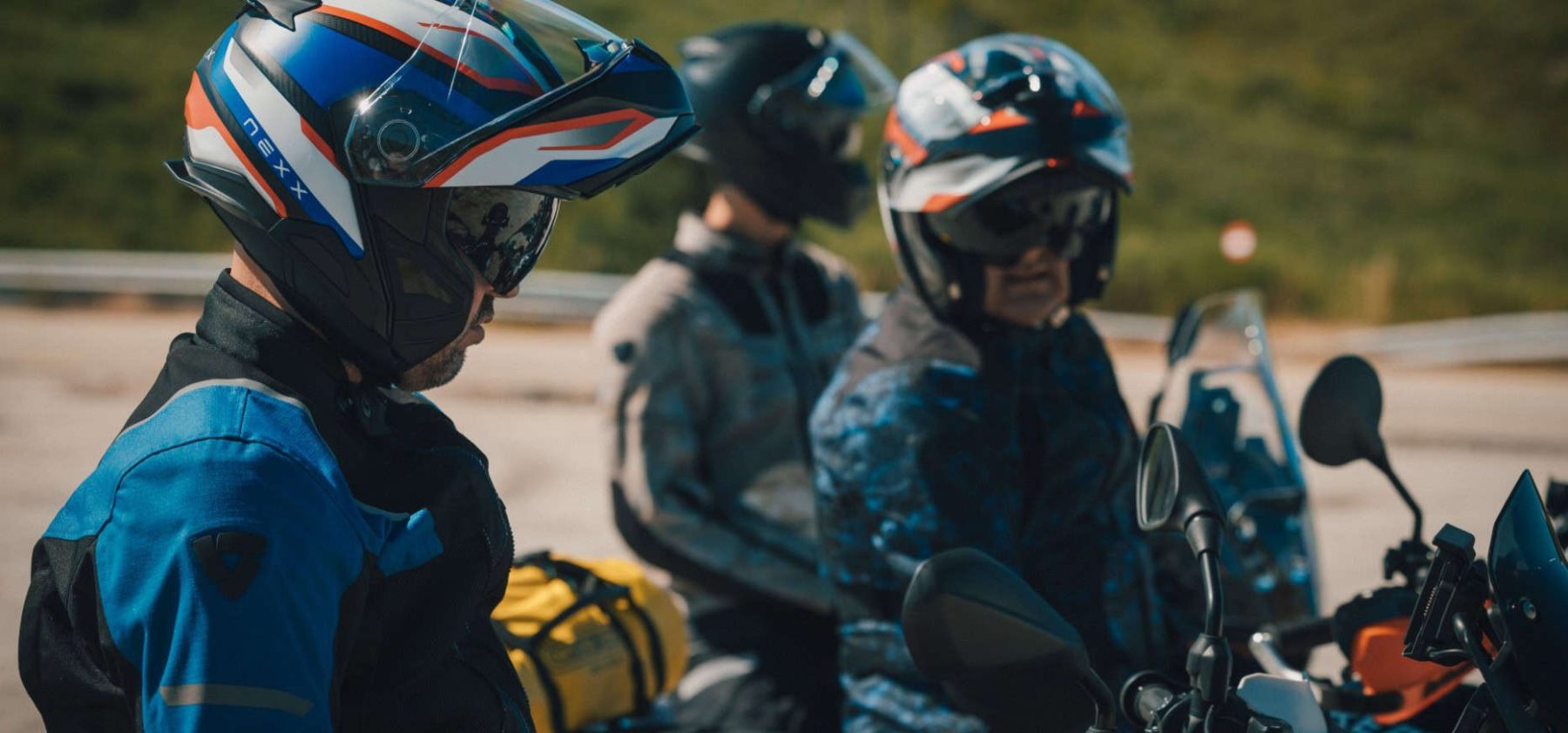 Three riders wearing Nexx X.Lifetour helmets during a road stop