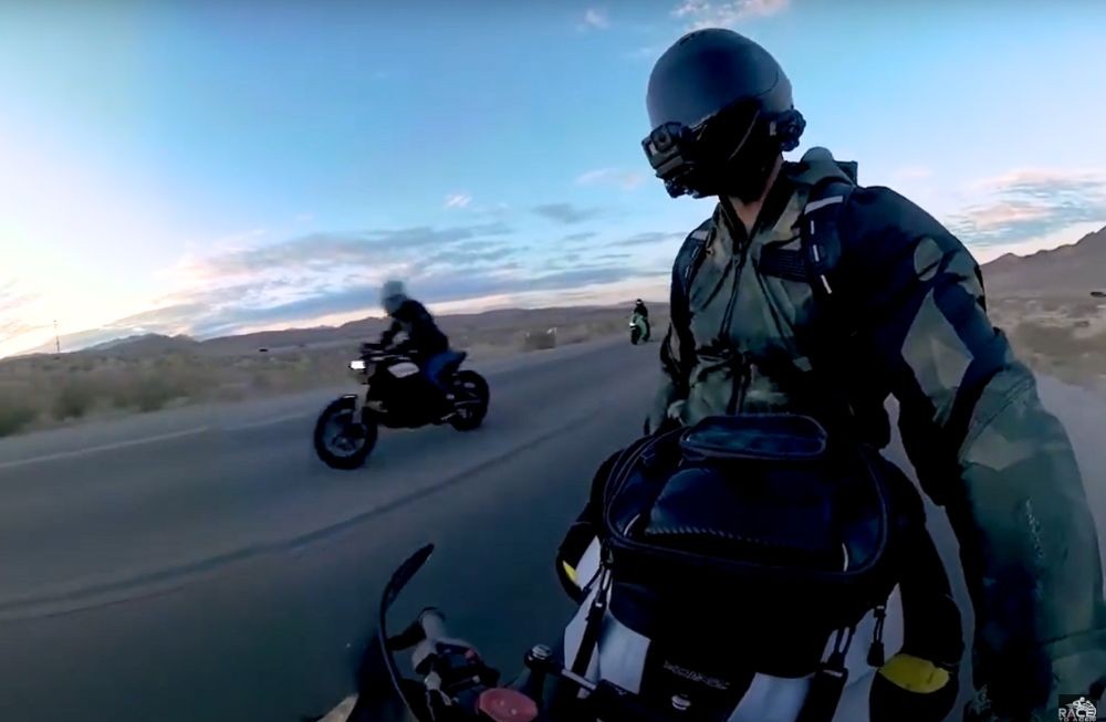 Motorcyclist wearing helmet and gear during a desert road ride at sunset