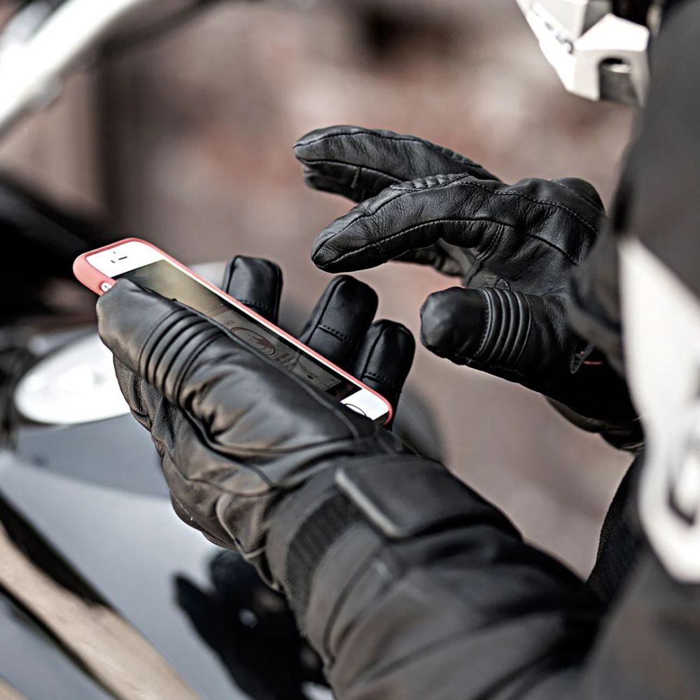 Rider wearing heated motorcycle gloves using smartphone touchscreen with ease