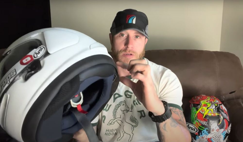 Rider demonstrating the thick rubber base of the Arai Corsair X helmet during a safety breakdown