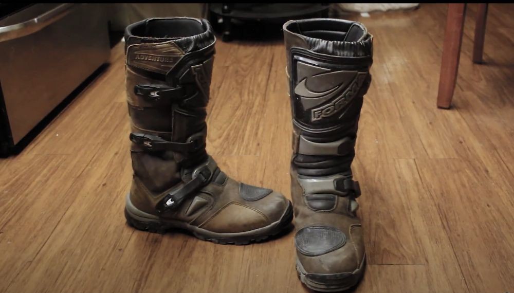 Worn brown Forma Adventure Boots standing upright on a wooden floor