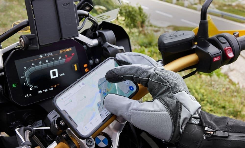 Motorcyclist using a GPS app on a smartphone with touchscreen-compatible gloves