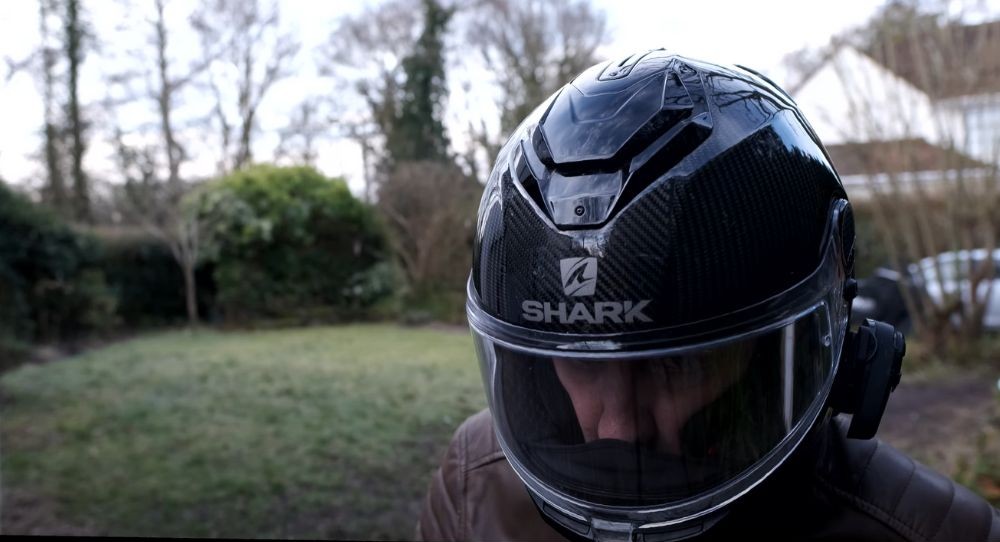 Front view of rider wearing Shark Spartan GT Carbon helmet, showing forehead vent and chin curtain