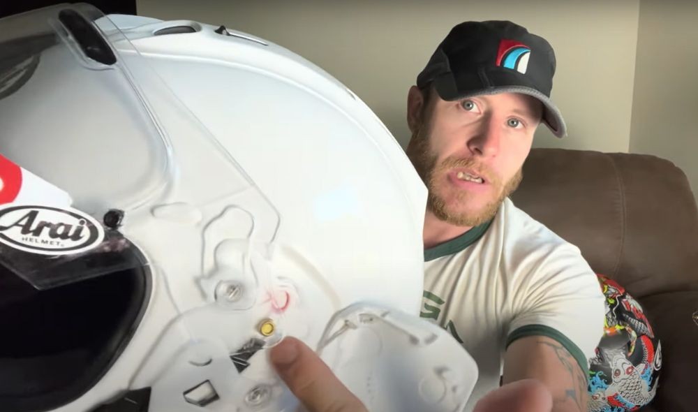Demonstrating how to remove the visor on an Arai Corsair X using the side tab release system