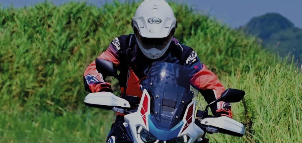 Motorcyclist in an Arai Tour-X5 adventure helmet riding a Honda Africa Twin