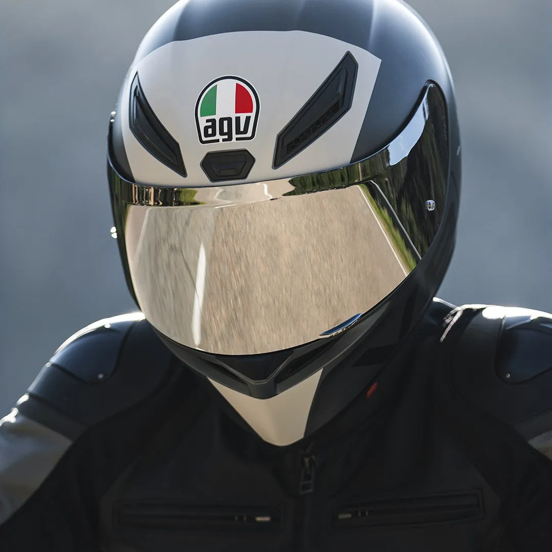 Motorcyclist wearing an AGV K1 S helmet with a mirrored visor and black-and-white shell, viewed head-on in riding gear.