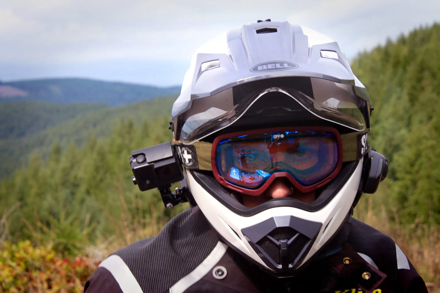 Rider wearing a Bell ADV helmet with face shield up and goggles underneath, equipped with camera and comms system