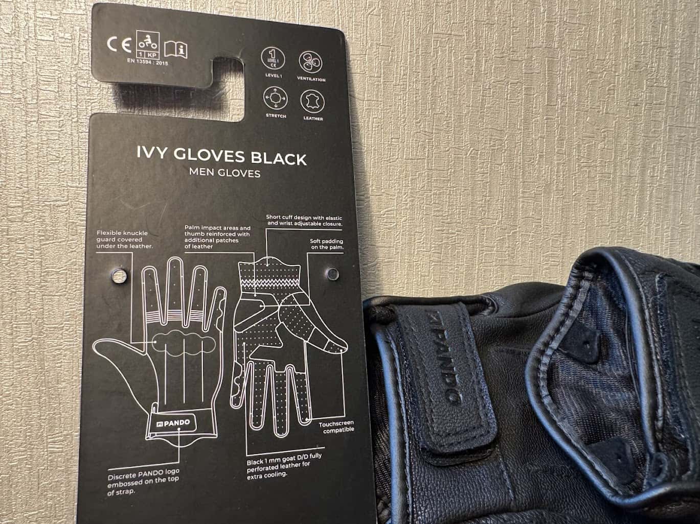 Close-up of Pando Moto Ivy Gloves tag showing CE certification and glove features