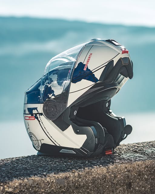 Schuberth C5 modular helmet with drop-down sun visor and clear face shield resting on a ledge.