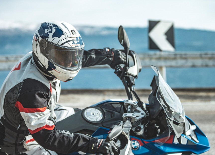 Motorcyclist wearing a Schuberth C5 helmet on a touring bike in mountain backdrop