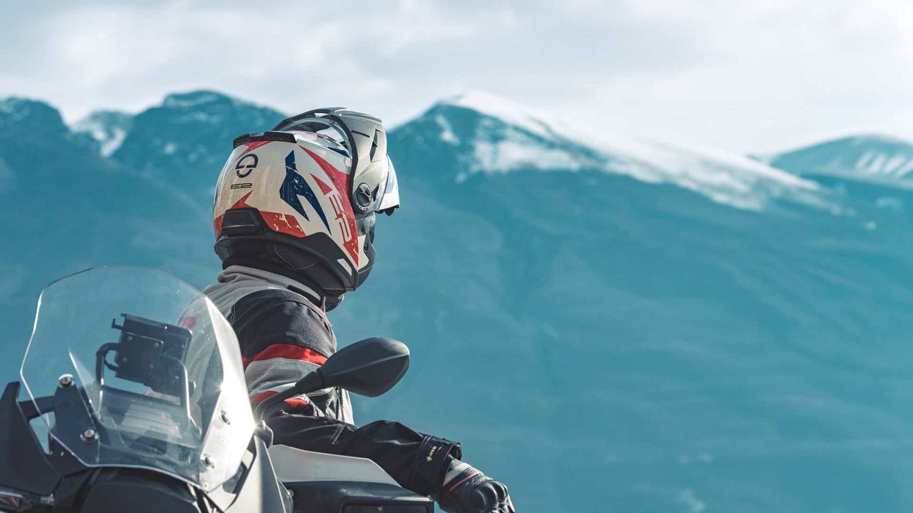 Motorcyclist wearing Schuberth E2 helmet riding through the mountains