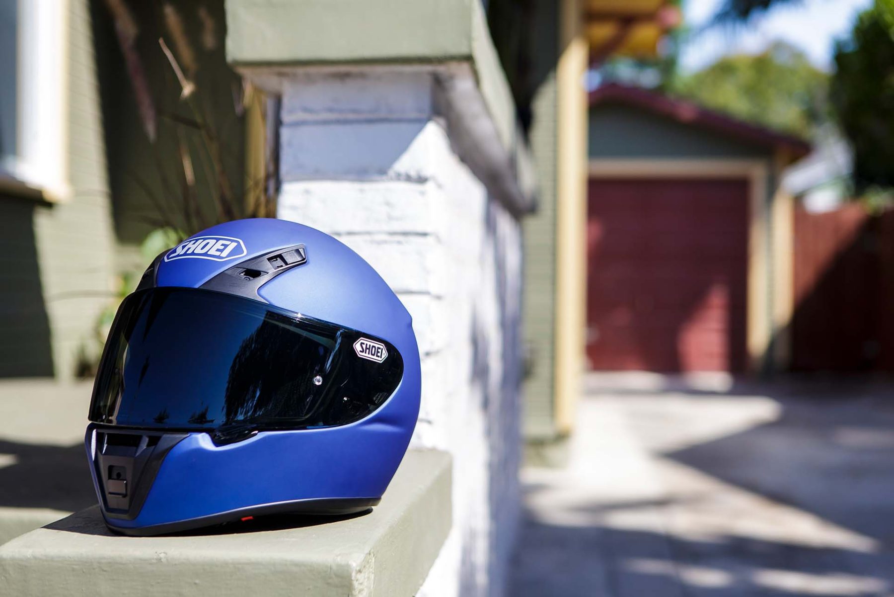 Shoei RF-SR full-face helmet resting on a low wall in sunlight