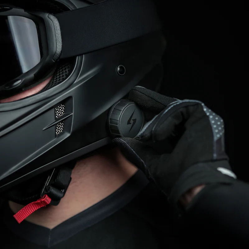 Gloved rider adjusting Syphon SoundPro Ultra Thin speaker control dial on motorcycle helmet