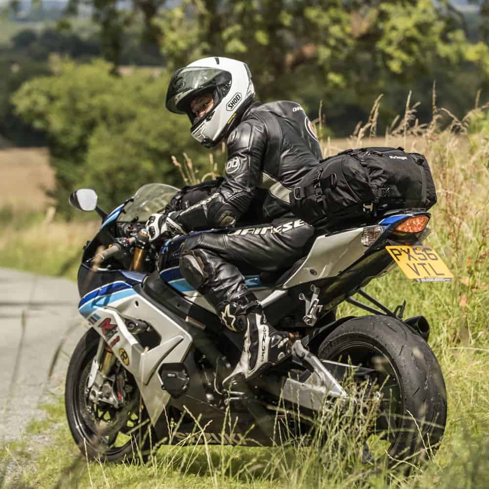 Motorcyclist riding sportbike with Kriega luggage on rural road