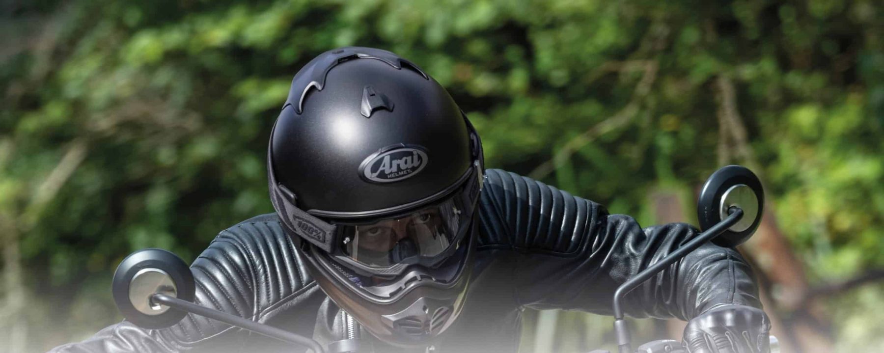 Motorcyclist wearing an Arai Tour-X5 adventure helmet and black leather gear