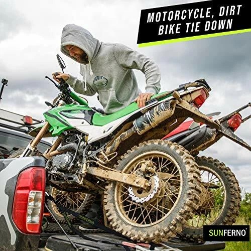 Man securing dirt bike in truck bed using Sunferno ratchet straps for transport