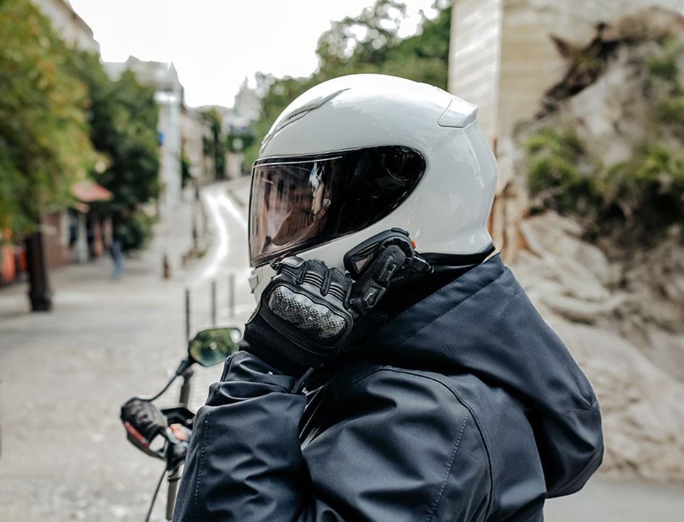 Motorcyclist in city setting wearing a helmet with a Sena 5S Bluetooth headset installed.