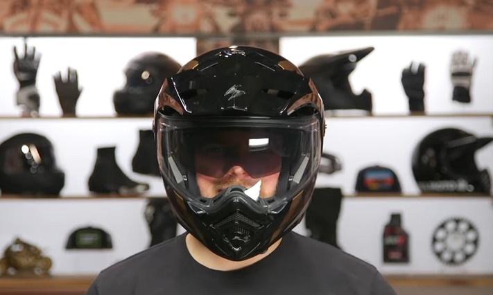 Rider wearing a ScorpionEXO AT960 modular adventure helmet in black during a gear review