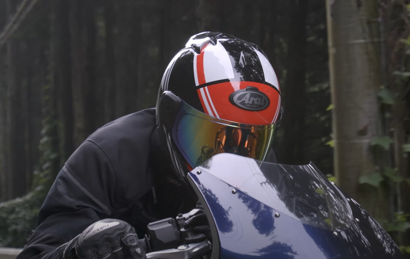 Rider wearing an Arai XD-5 helmet with tinted face shield while riding through forest road