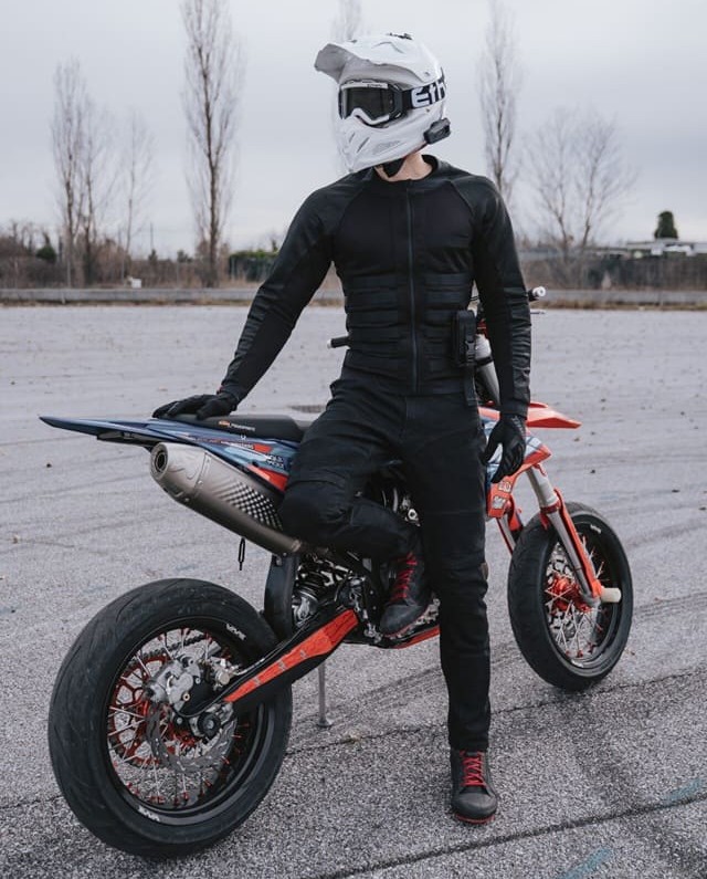 Rider on a supermoto wearing Pando Moto jacket with leggings hidden under casual pants, showing discreet fit and full protection.