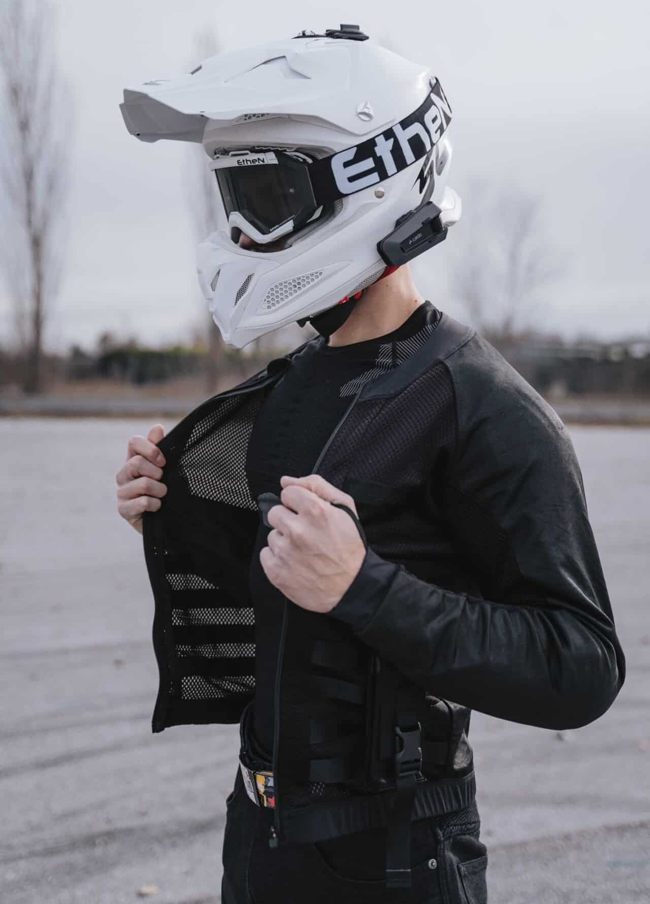 Close-up of rider wearing Pando Moto Commando jacket with MOLLE webbing and adjustable SAS-TEC armour pockets for protection.