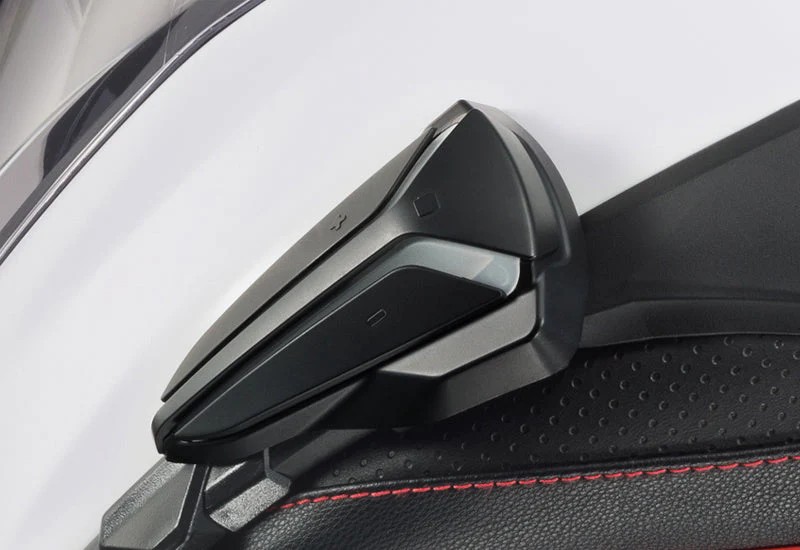 Close-up of HJC Smart HJC 20B communication unit mounted on the side of a helmet, showing external installation design.