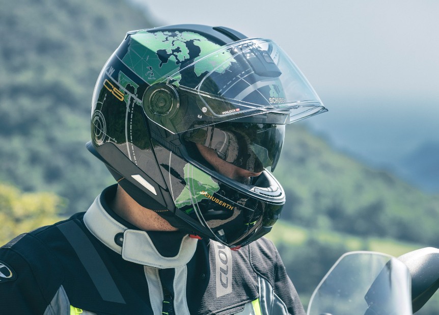 Rider wearing a Schuberth C5 modular helmet on a BMW touring motorcycle near water