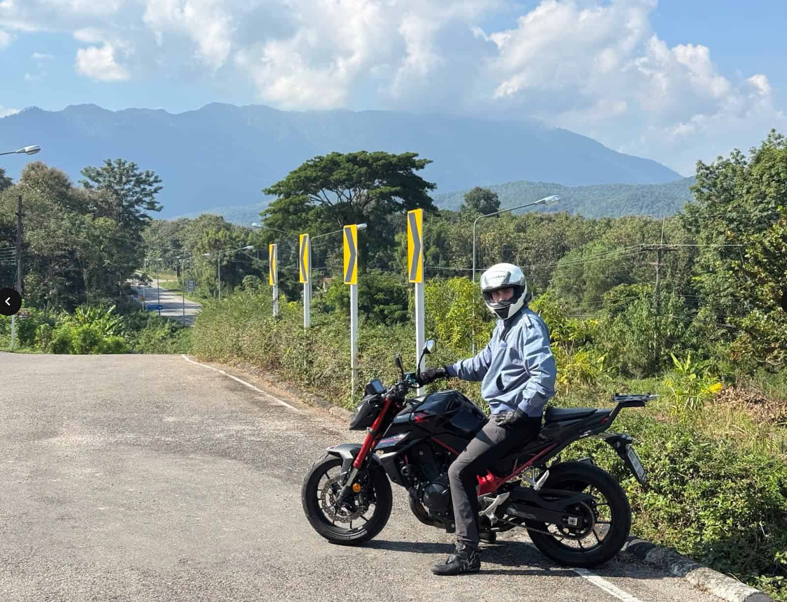 Rider wearing Shoei RF-SR helmet on motorcycle with scenic mountain backdrop