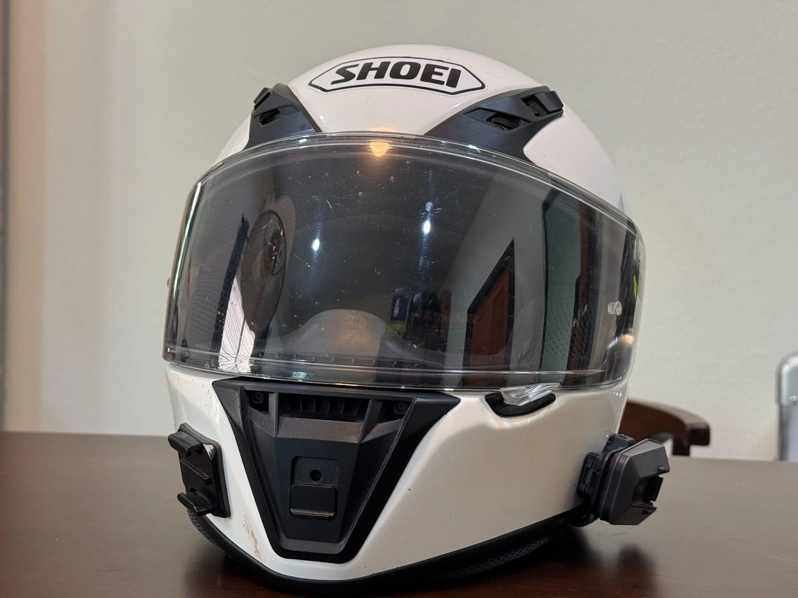 Shoei RF-SR full-face helmet front view in white with clear visor and comms units attached