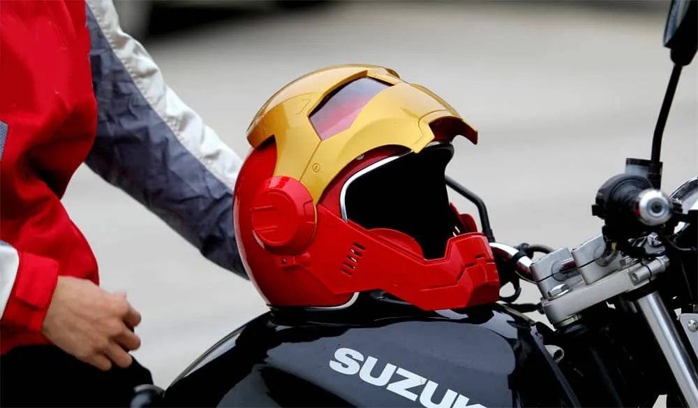 Iron Man–style motorcycle helmet resting on a Suzuki bike, blending comic book flair with real-world riding.