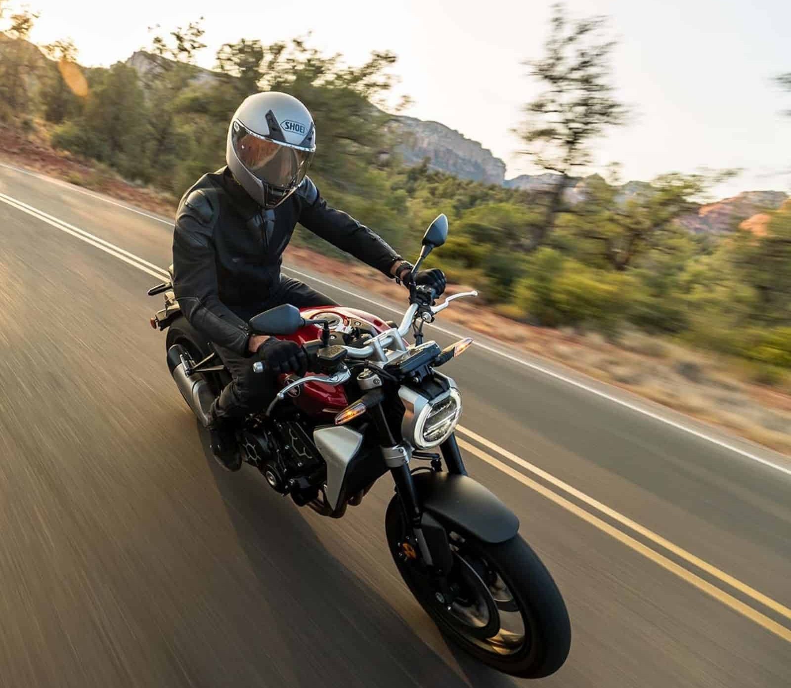 Rider wearing Shoei RF-SR helmet on a naked bike cruising through scenic roads