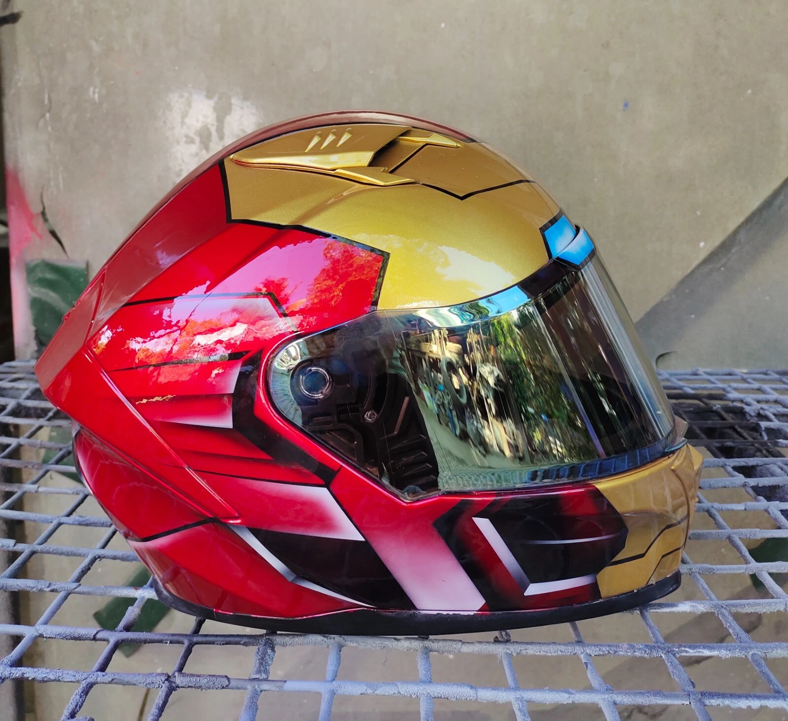 Custom Iron Man–themed full-face motorcycle helmet with red, gold, and black detailing.
