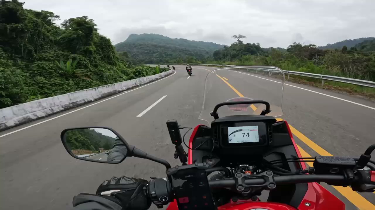 Rider’s perspective on open road with motorcycle dashboard and speedometer visible