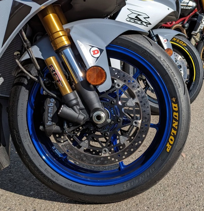 Close-up of a sportbike front wheel fitted with Dunlop Q5S Sportmax tire, highlighting tread and braking setup
