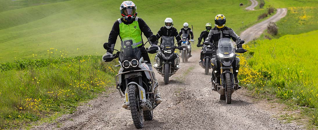 Group of adventure riders on mixed terrain with dual-sport tires
