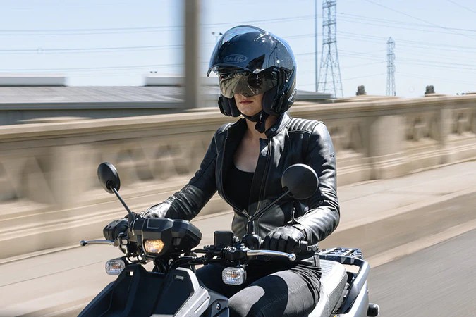 Rider wearing HJC RPHA 31 helmet, a lightweight open-face with sport performance design.