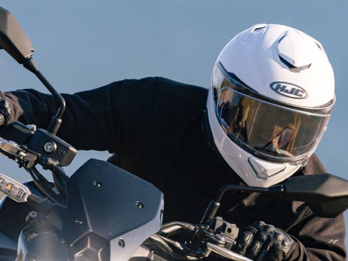 Rider wearing HJC RPHA 72 full-face helmet leaning into a turn on a sport bike