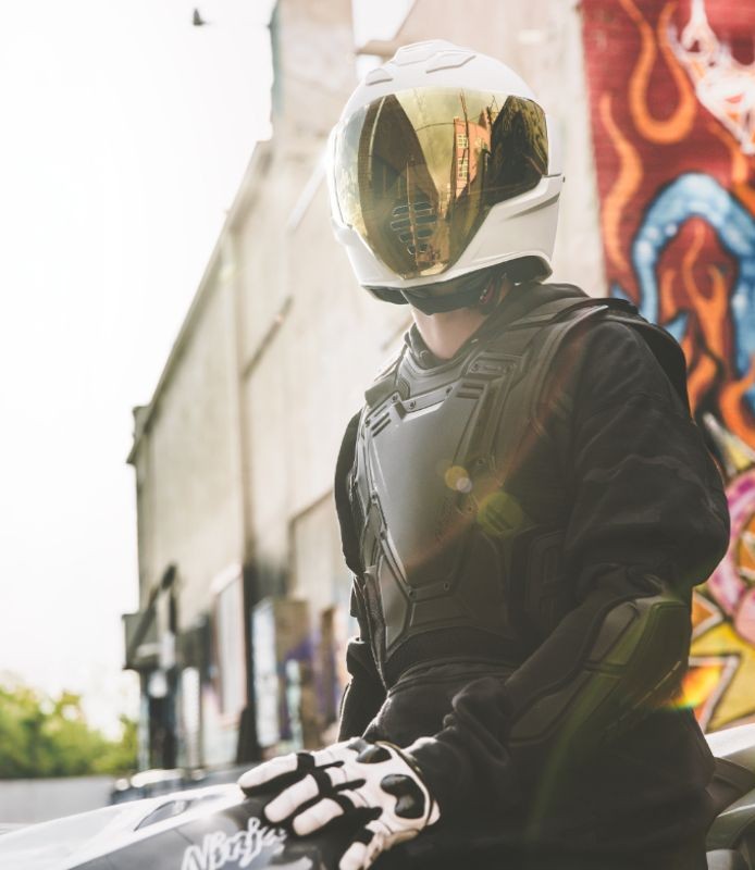 Rider wearing Icon Field Armor Stryker vest with helmet in urban setting
