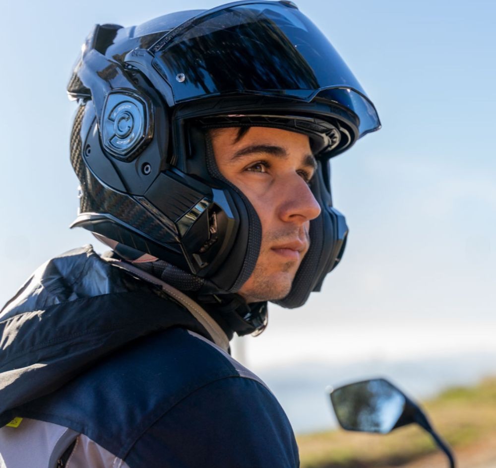 Rider wearing LS2 Advant X helmet with chin bar flipped back for open-face use