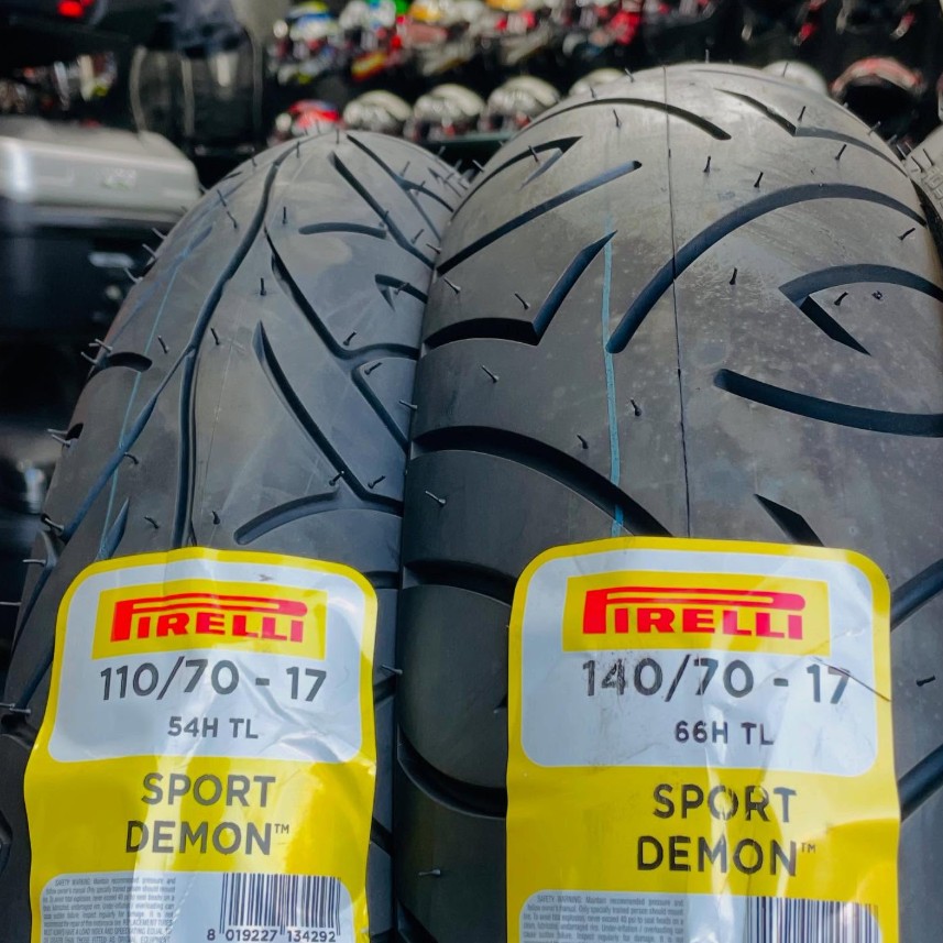 Pair of Pirelli Sport Demon motorcycle tires with yellow labels, showing tread detail