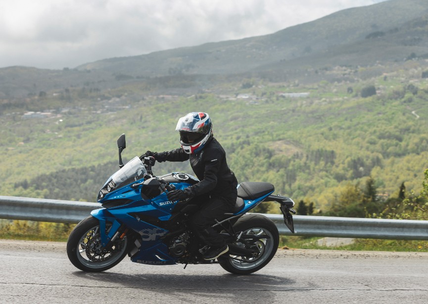 Rider wearing Schuberth S3 helmet on a blue Suzuki sport-touring bike, showcasing aerodynamic design and venting performance.