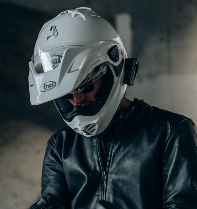 Rider in leather jacket wearing white Arai XD5 adventure helmet with peak and visor