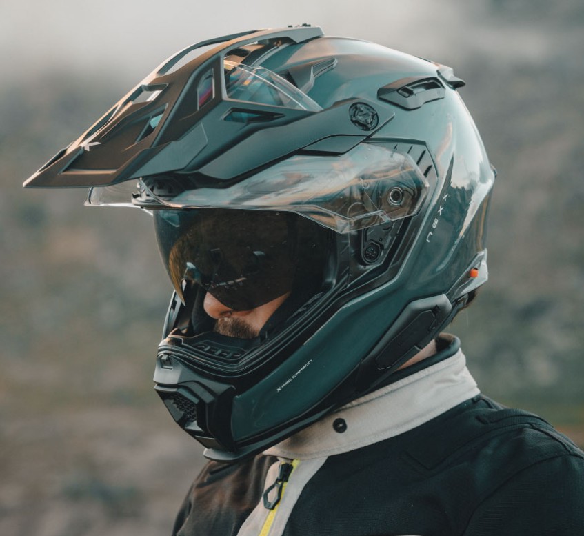 Close-up of rider wearing Nexx X.WED3 helmet with drop-down sun visor and peak extender